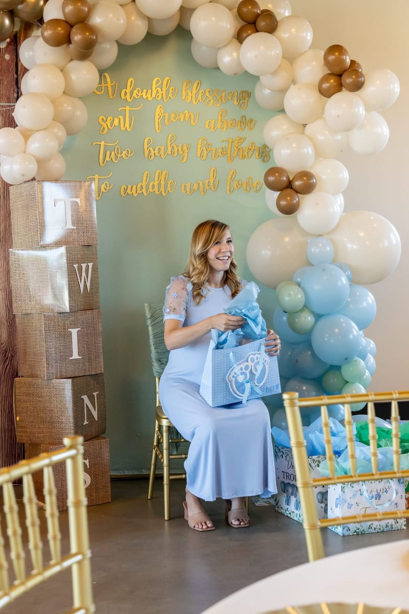 Guest of honor opening gifts at a twin baby shower at The Chestnut Hall
