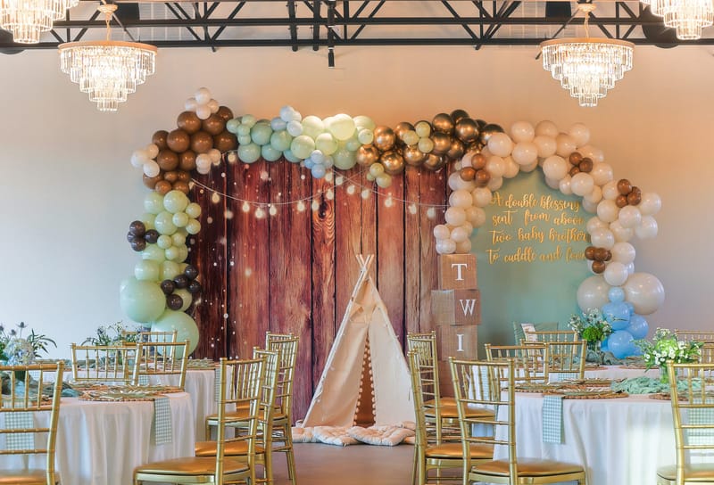 Baby shower balloon arch and woodland backdrop in the main hall